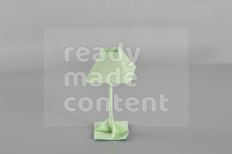Origami floor lamp on grey background
