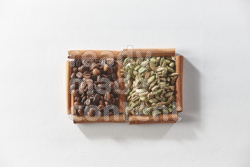2 squares of cinnamon sticks full of cardamom and coffee beans on white flooring