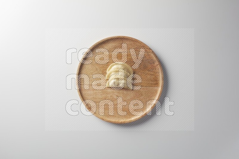 Three Sambosas on a wooden round plate on a white background