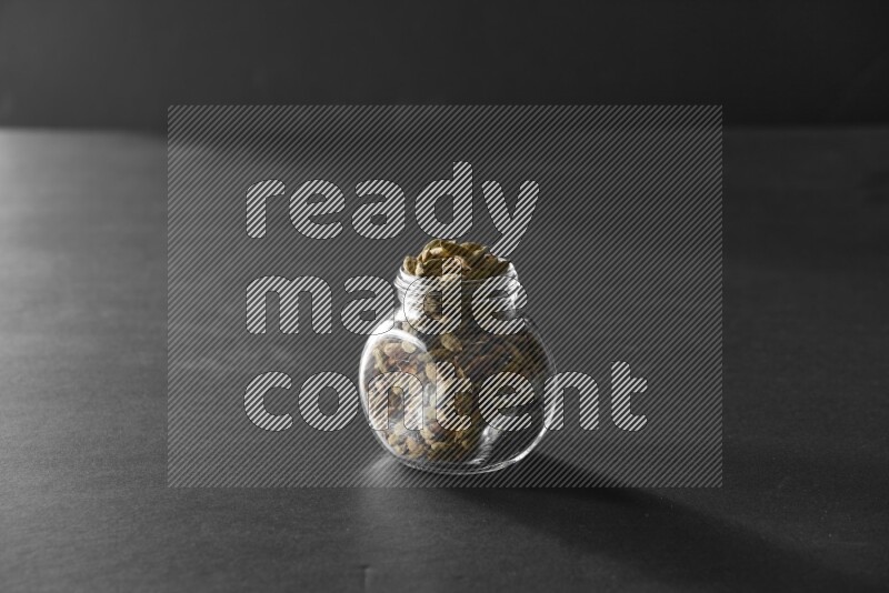 هيل في وعاء زجاجي علي خلفية سوداء