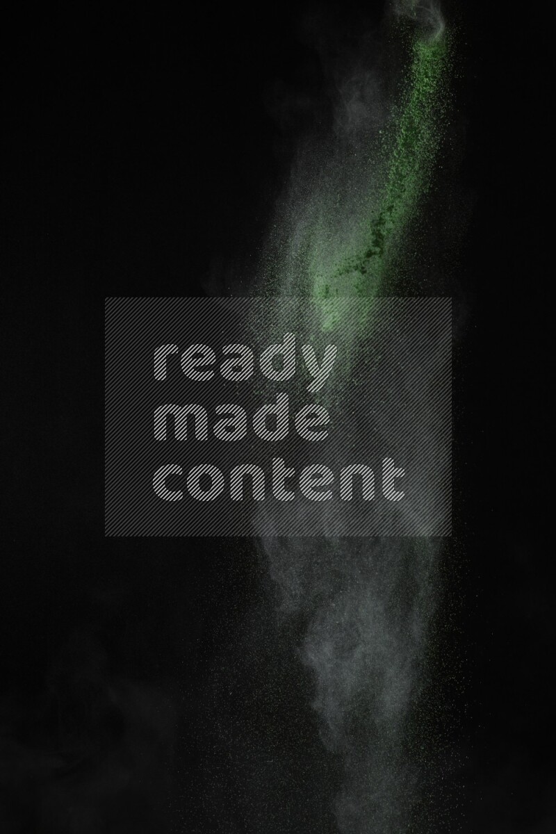 A side view of green powder explosion on black background