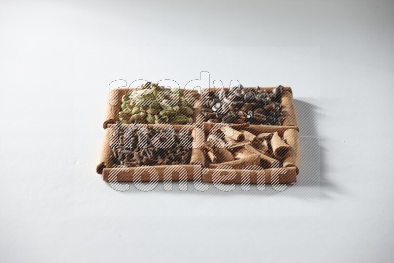 4 squares of cinnamon sticks full of coffee beans, cinnamon, cloves and cardamom on white flooring