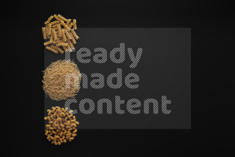 Different pasta types in 3 bunches on black background