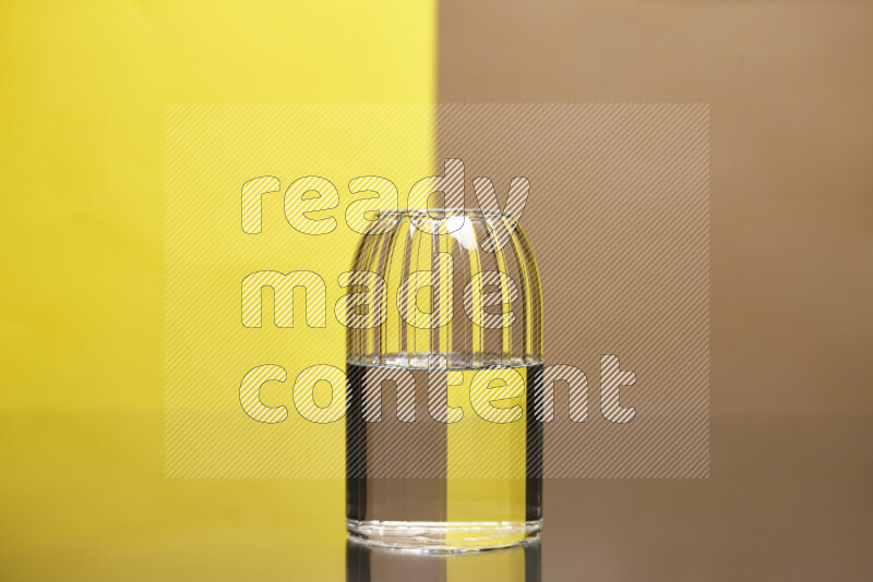 The image features a clear glassware filled with water, set against yellow and beige background