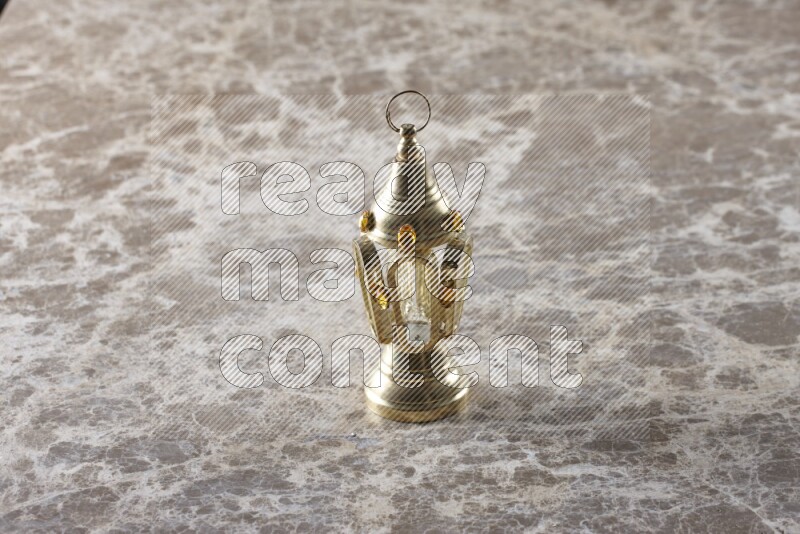 A lantern placed on a beige marble background