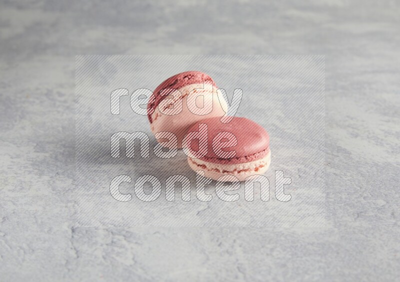45º Shot of two Pink Litchi Raspberry macarons  on white  marble background