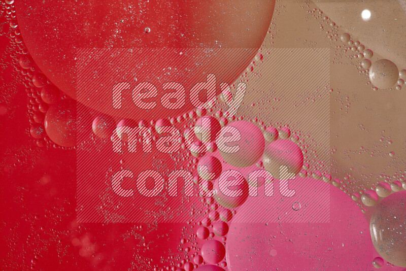 Close-ups of abstract oil bubbles on water surface in shades of brown, red and pink