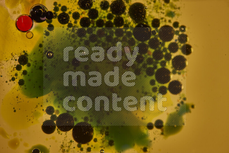 لقطات مقربة لقطرات ألوان مائية خضراء وسوداء وحمراء على سطح الزيت على خلفية صفراء