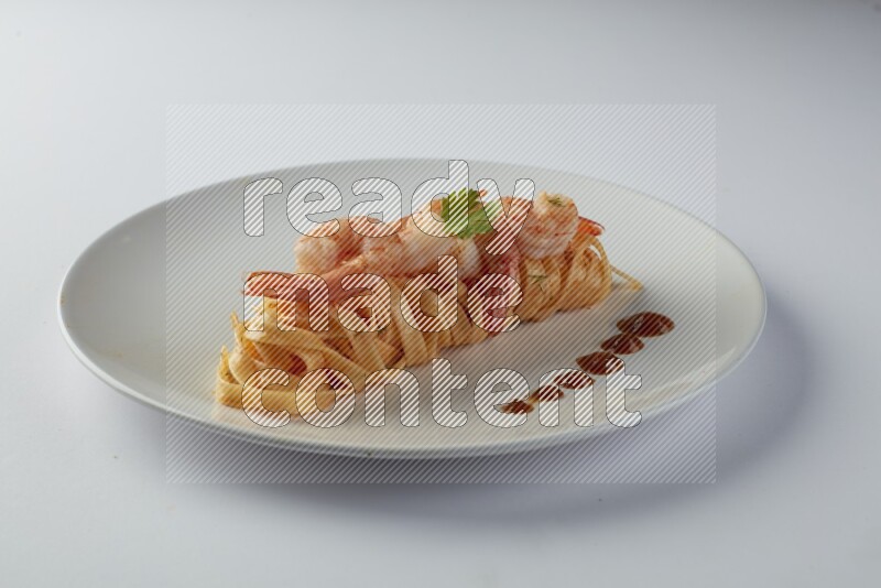 Fettuccini red sauce pasta with shrimp in a white plate on a white background