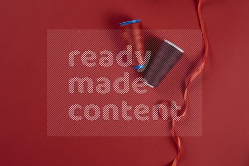 A red collection of sewing and tailoring tools arranged on a red background