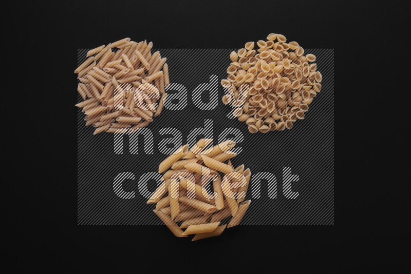 Different pasta types in bunches on black background