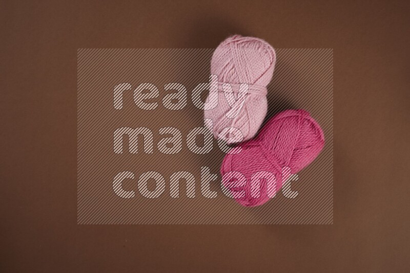 مجموعة من أدوات الخياطة والتفصيل زهرية اللون على خلفية بنية