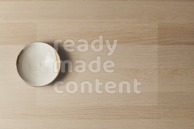 A multicolored pottery plate on light wooden background