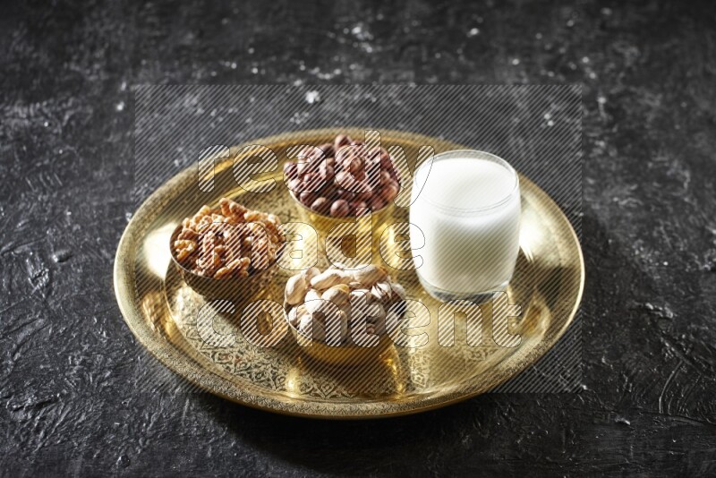 Nuts in metal bowls with sobya on a tray in dark setup