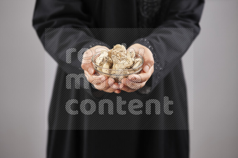 Woman in abaya holding different kinds of spices in different positions