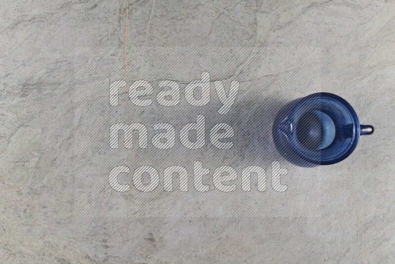 A colored glass jug on grey marble background
