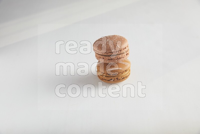 45º Shot of of two assorted Brown Irish Cream, and Brown Hazelnuts macarons on white background