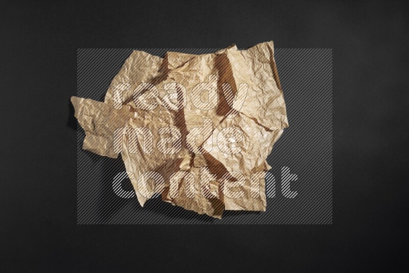 Crumpled craft paper on black background