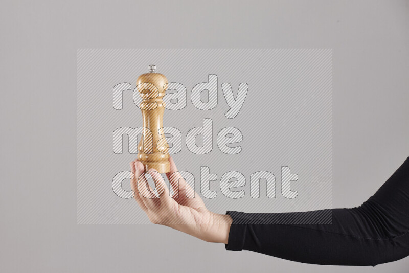 A woman in black abaya holding different wooden essentials in different positions