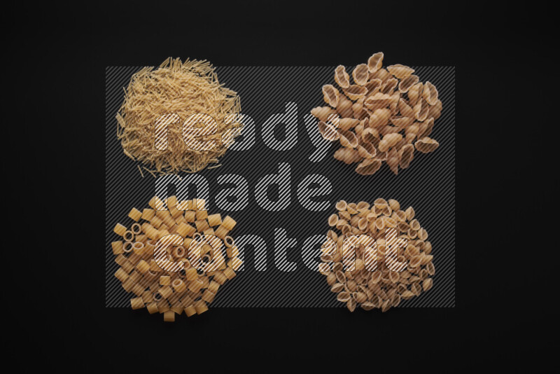 Different pasta types in bunches on black background