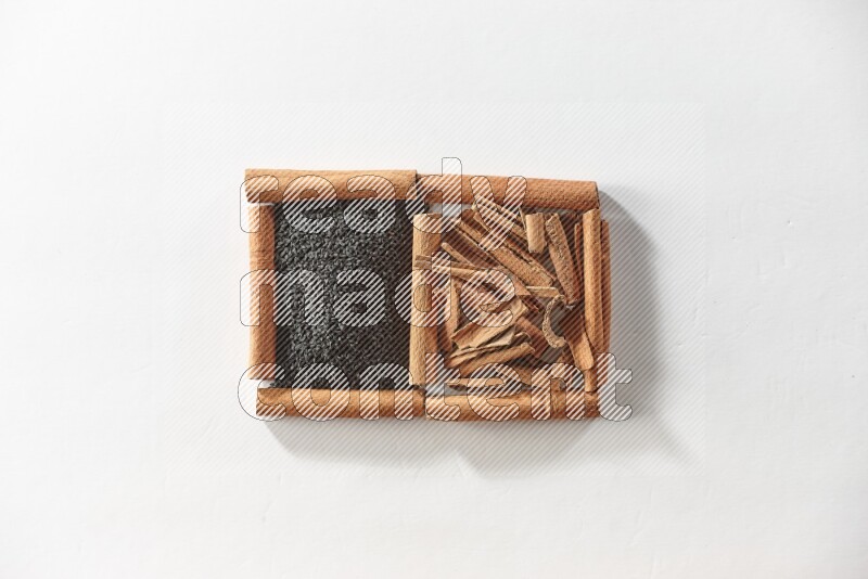 2 squares of cinnamon sticks full of black seeds and cinnamon on white flooring