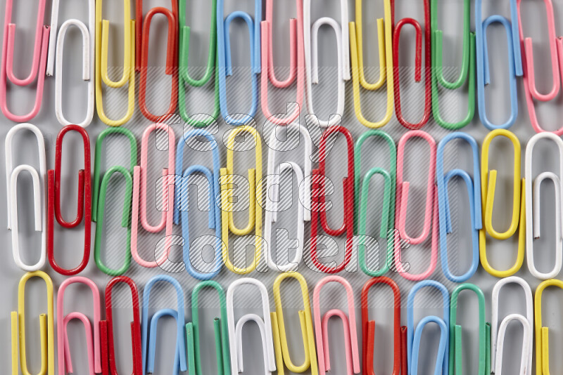 Multicolored paper clips isolated on a grey background