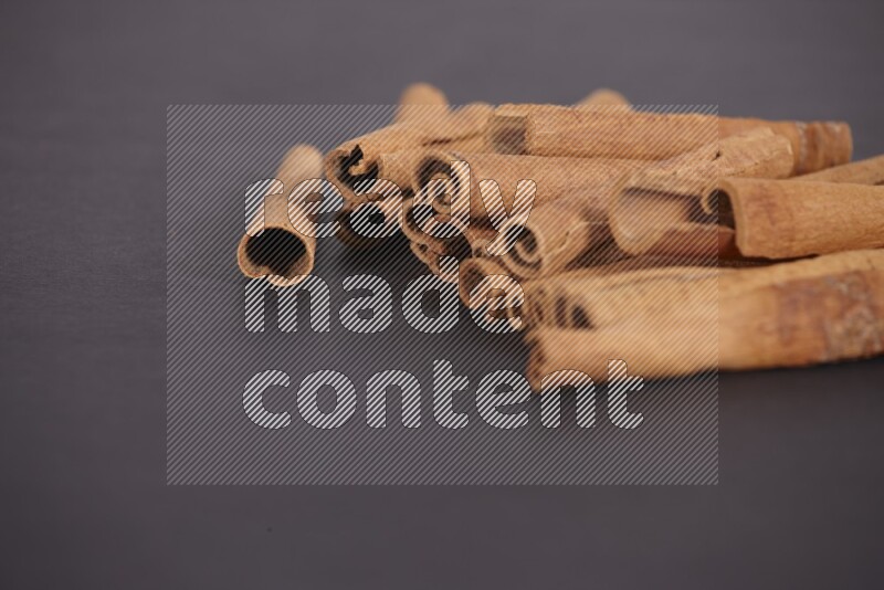 Cinnamon sticks stacked on black flooring
