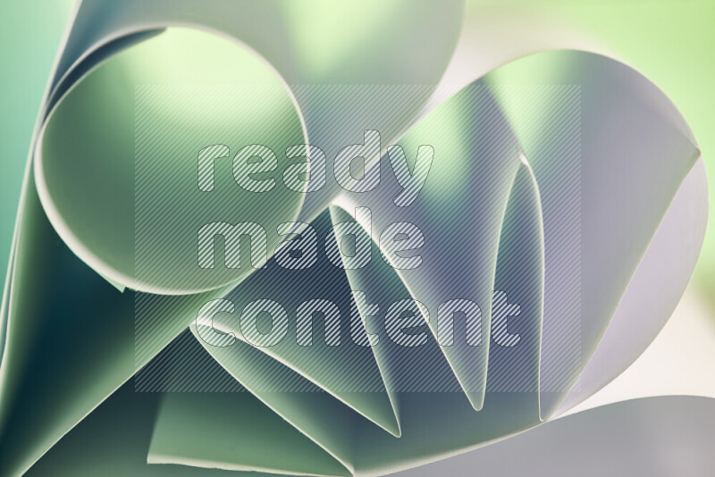 An artistic display of paper folds creating a harmonious blend of geometric shapes, highlighted by soft lighting in green and red tones