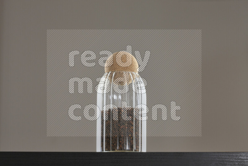 قرنفل في وعاء زجاجي على خلفية سوداء