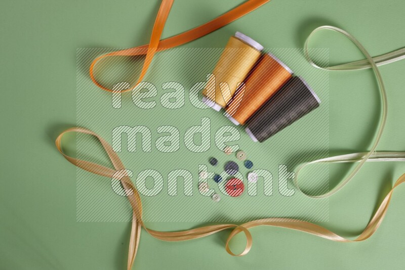 A collection of sewing and tailoring tools arranged on a green background