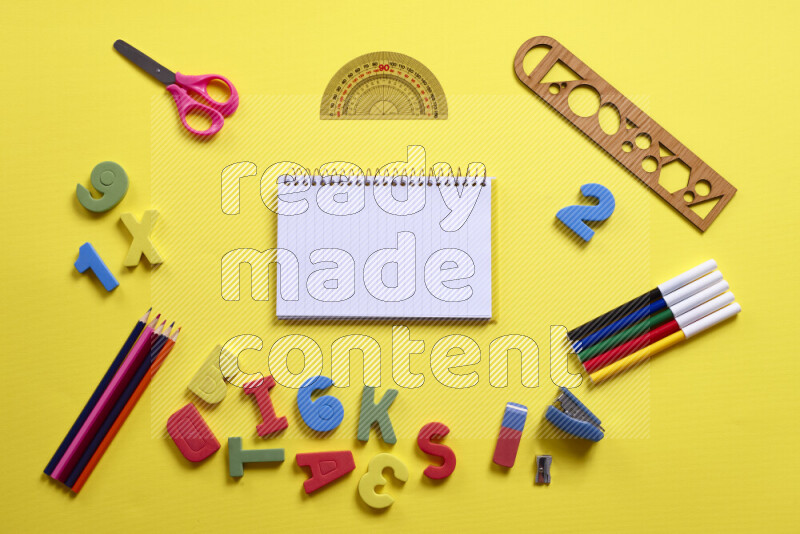 Different school supplies on yellow background