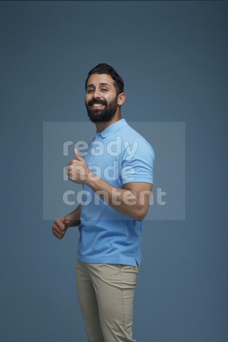 Man posing in a blue background wearing a Blue shirt