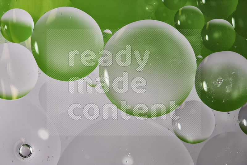 Close-ups of abstract oil bubbles on water surface in shades of white and green