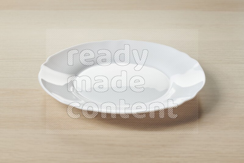 A white ceramic circular plate on light wooden background