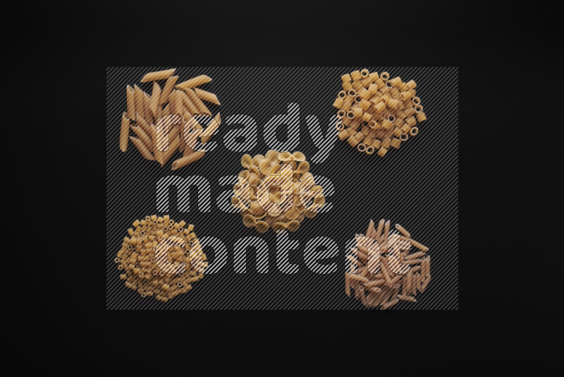 Different pasta types in bunches on black background