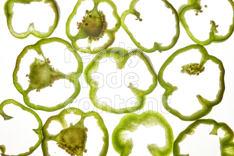 Green bell pepper slices on illuminated white background