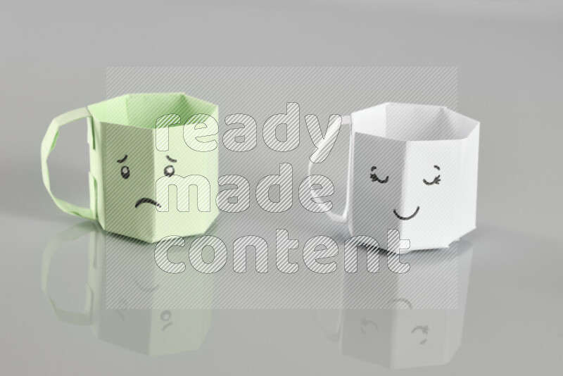 Origami cup on grey background