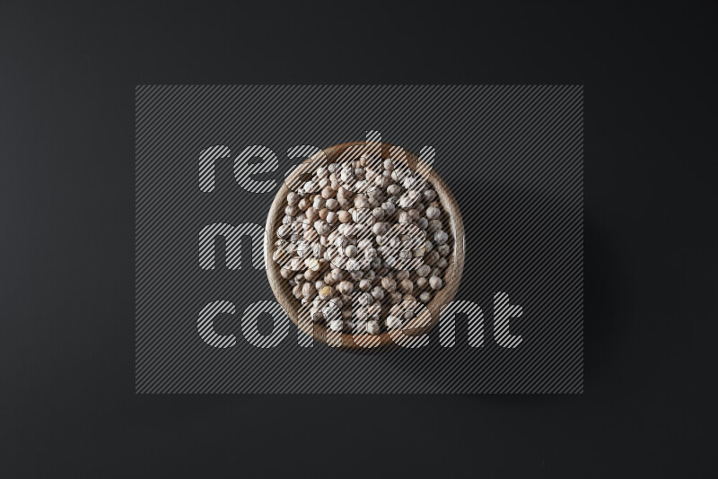 Chickpeas in a wooden bowl on grey background