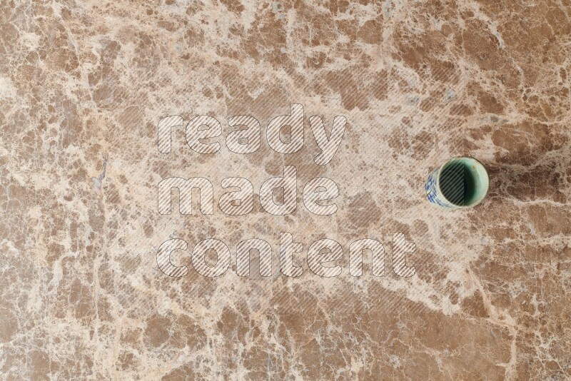 A pottery cup on beige marble background