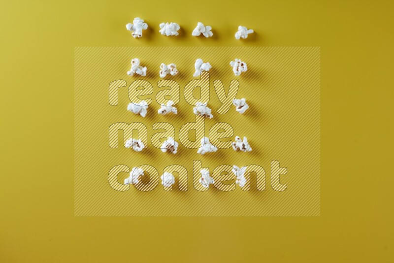 Popcorn flakes on a yellow background in different angles