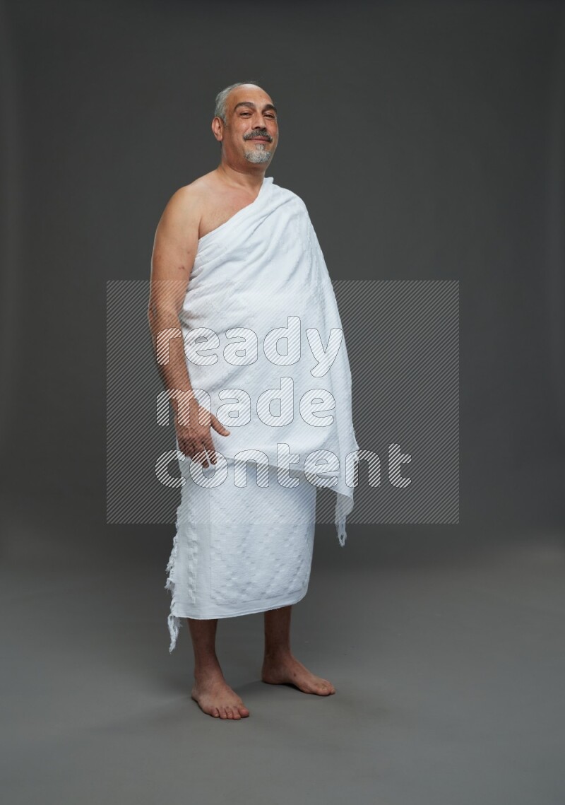 A man wearing Ehram Standing Interacting with the camera on gray background