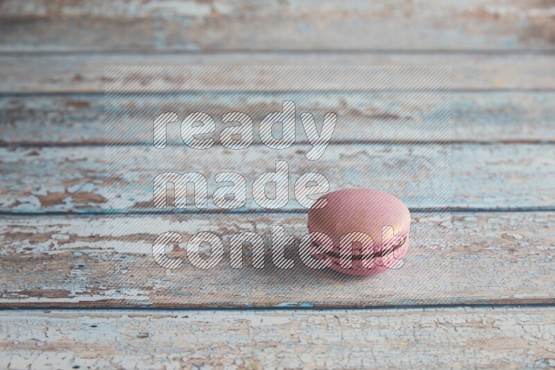 45º Shot of Purple Strawberry macaron on light blue wooden background