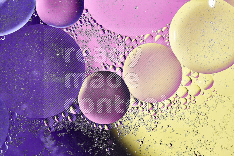 Close-ups of abstract oil bubbles on water surface in shades of yellow, purple and pink
