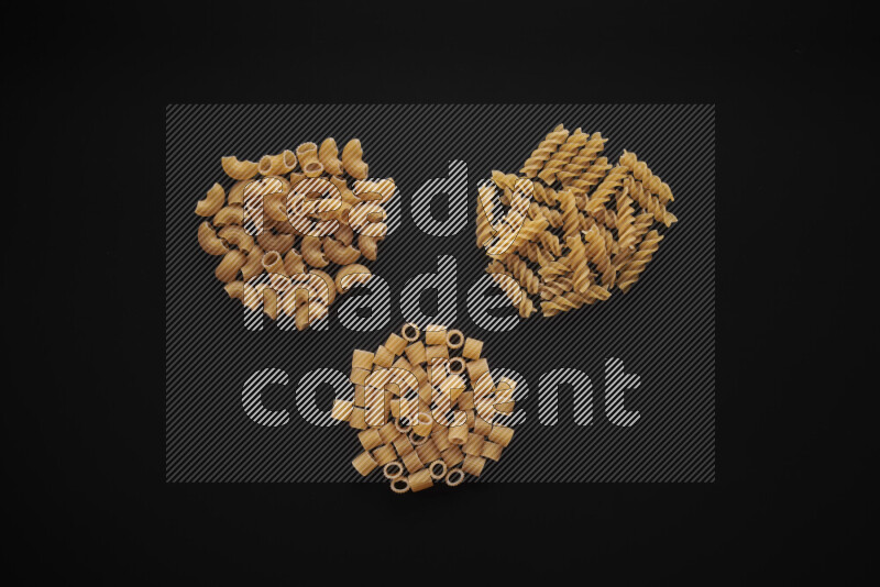 Different pasta types in bunches on black background