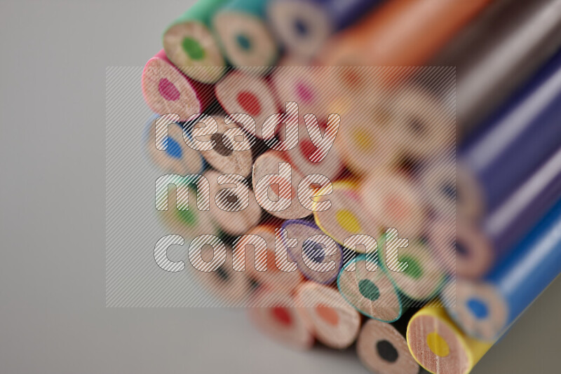 An array of colored pencils on grey background