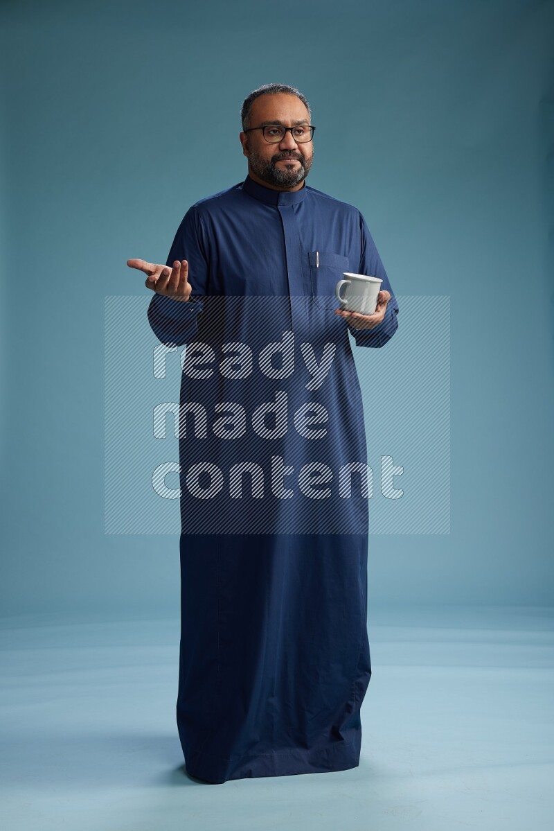 Saudi Man without shimag Standing drinking coffee on blue background