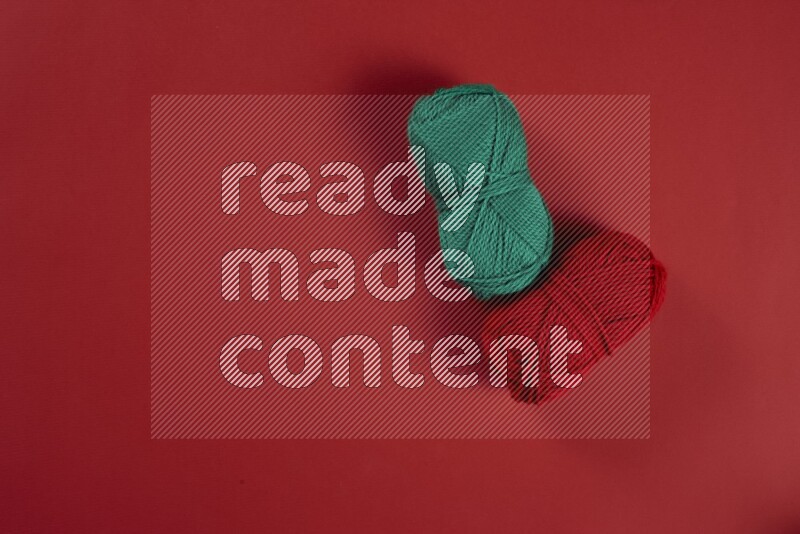 مجموعة من أدوات الخياطة والتفصيل خضراء وحمراء اللون على خلفية حمراء