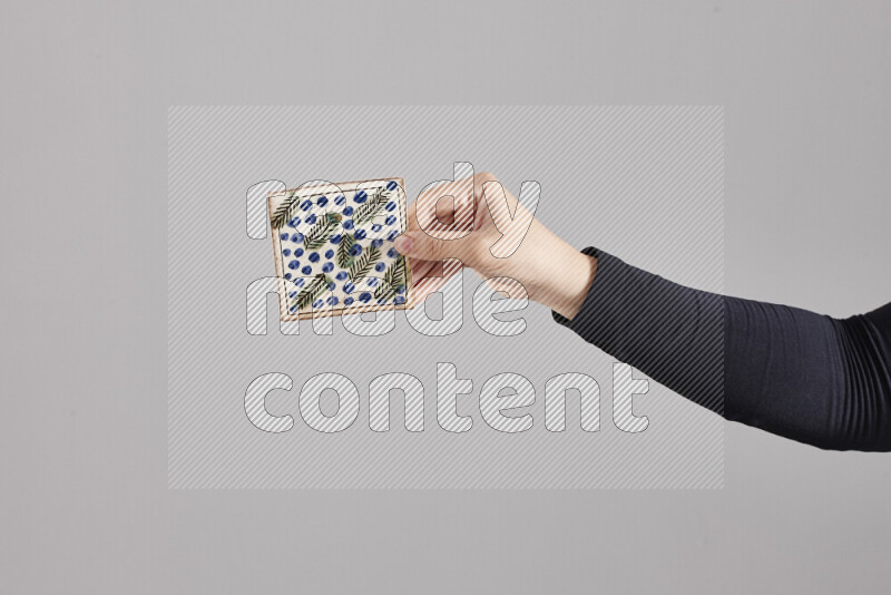 A woman in black abaya holding different pottery essentials in different positions