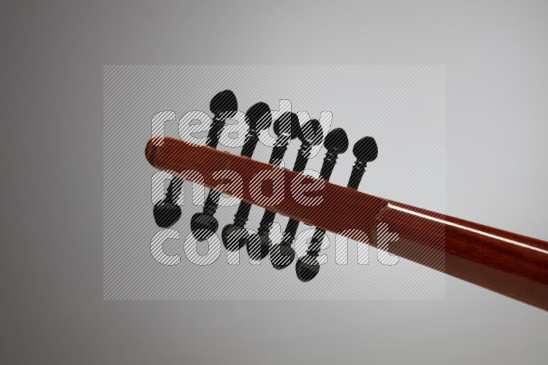 parts of a brown wooden Oud in a gray background