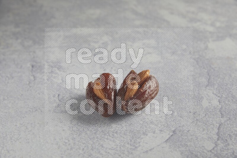 Two Almond stuffed date on a light grey background